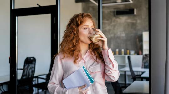 Vrouw met kop koffie en schrijfblok
